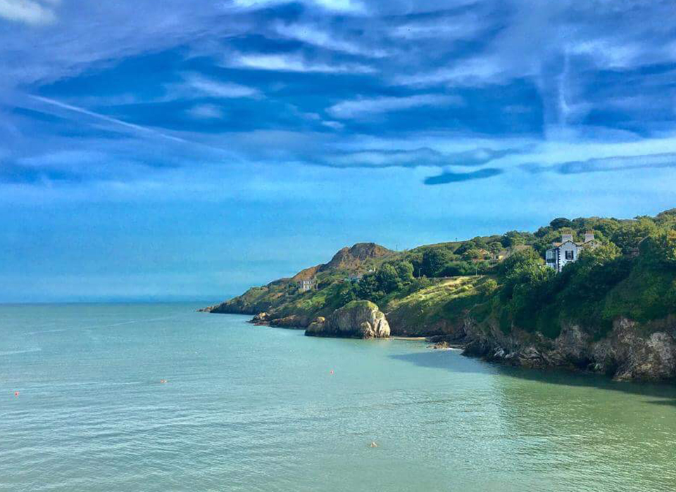 Panoramic view of Howth in Dublin with crisp blue sea and green cliff